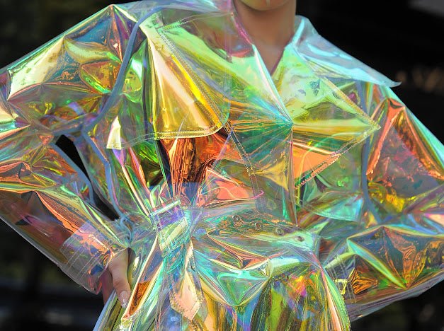 Futuristic longline iridescent jacket from the holographic vinyl trench coat collection.