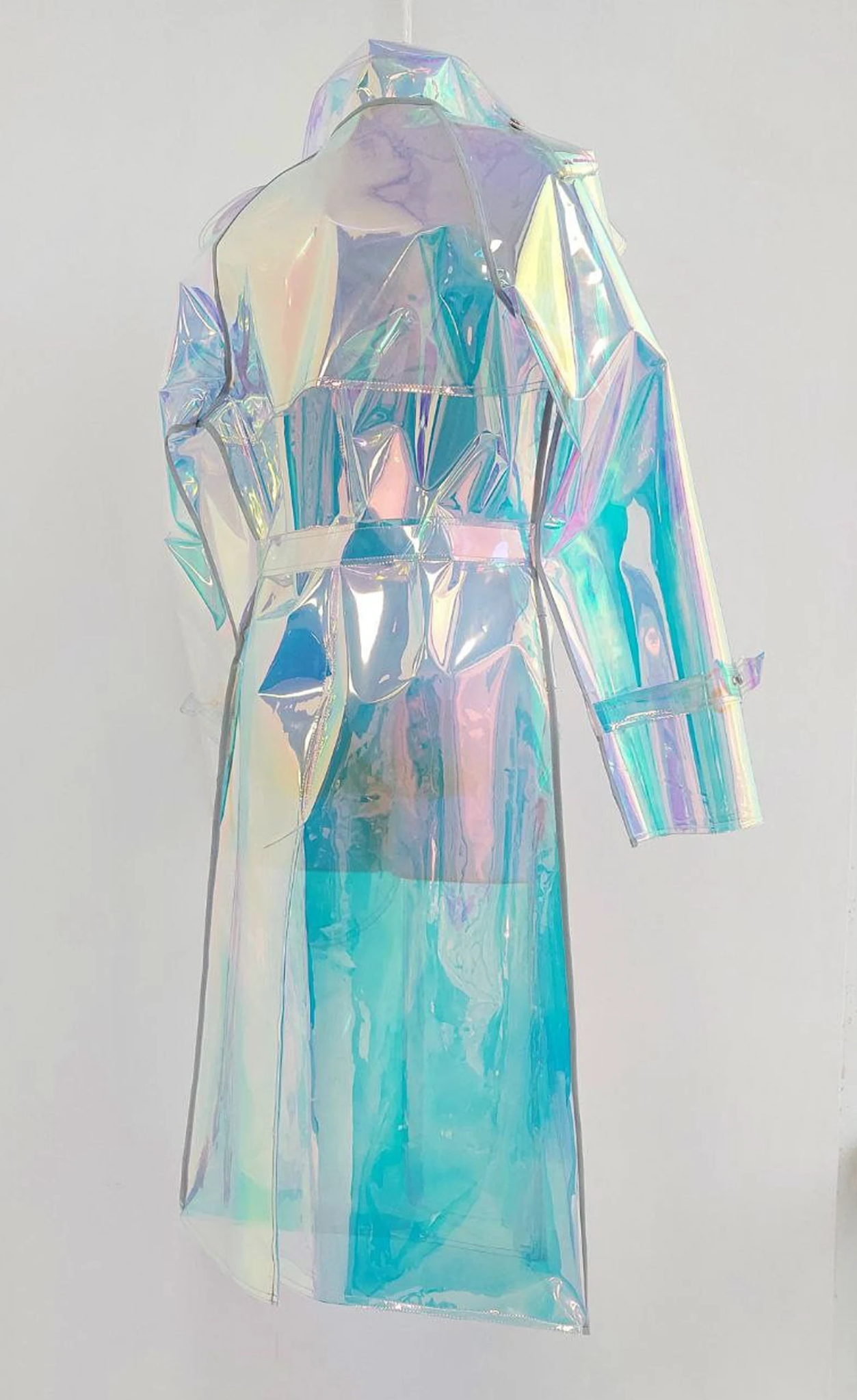 Model wearing a long holographic raincoat for men in a city setting.