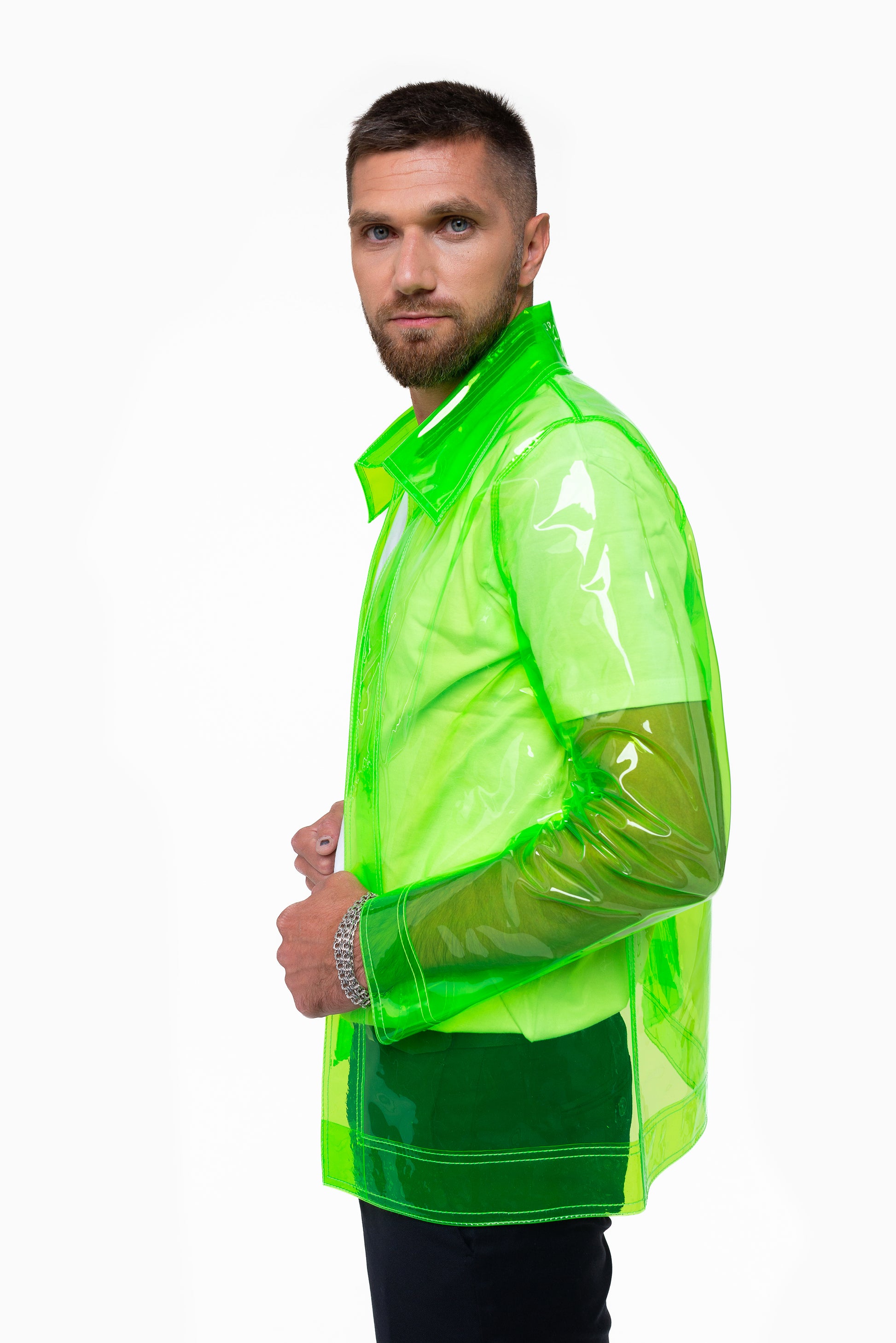The young man wearing a transparent neon green blazer on a white background side view