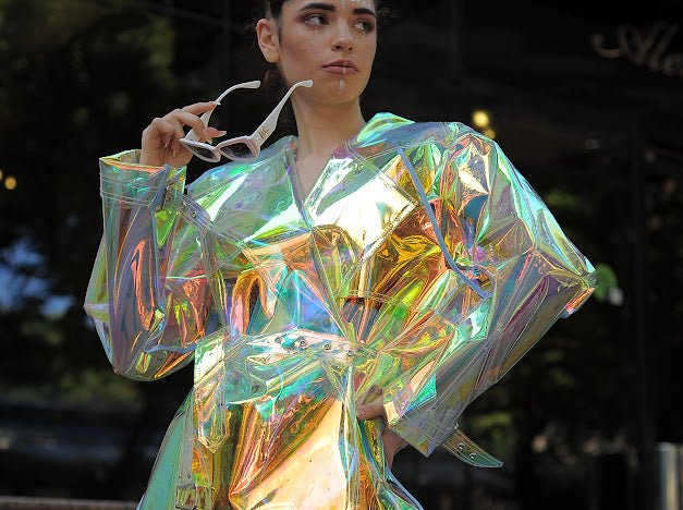 Model wearing the holographic vinyl trench coat iridescent festival outfit by Domdrich.