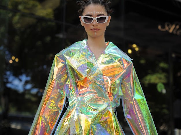 Futuristic longline iridescent jacket from the holographic vinyl trench coat collection.