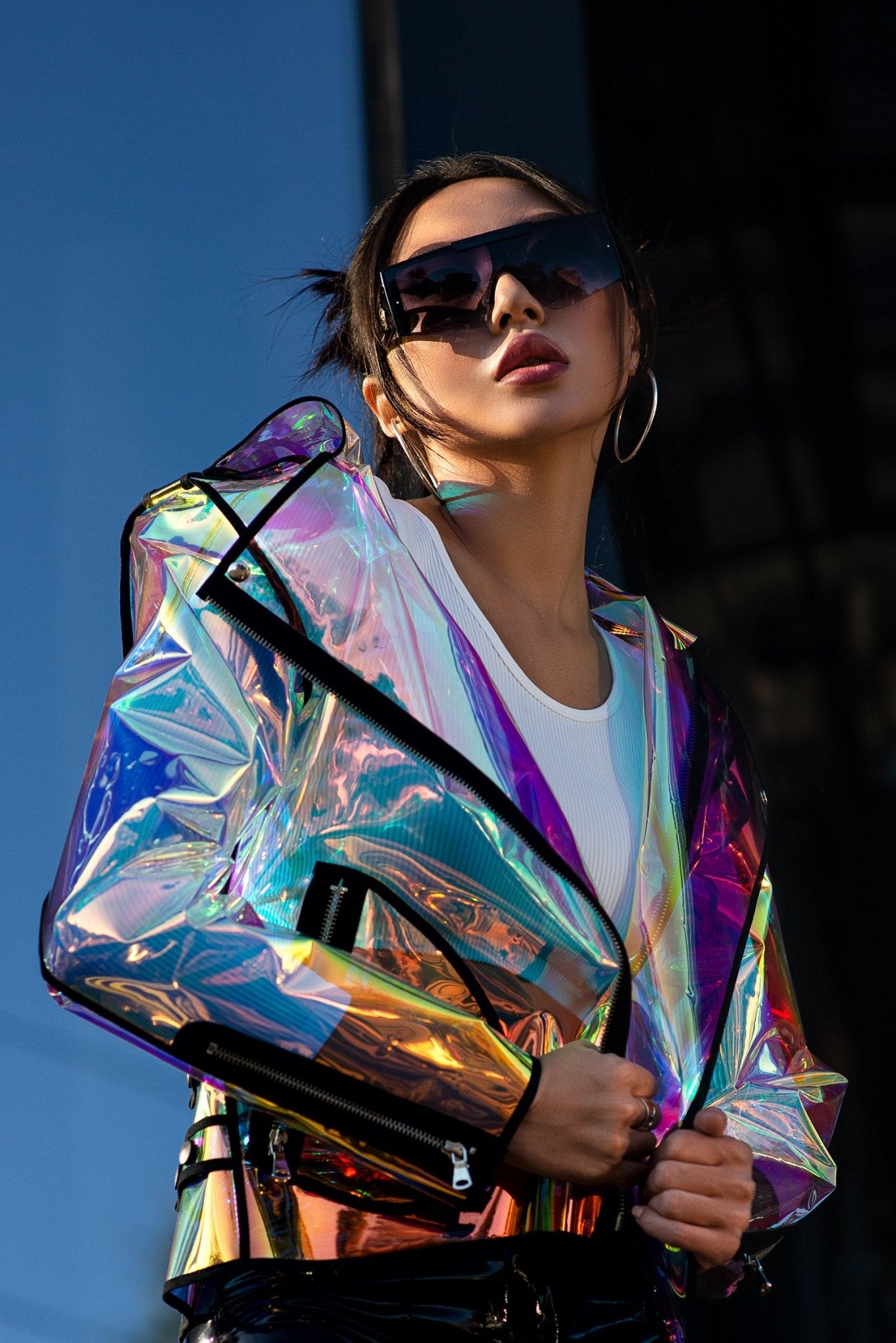 Model wearing a holographic biker jacket with a rainbow iridescent effect by Domdrich